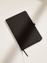 Load image into Gallery viewer, LDNA London black notebook against white background with shadows.