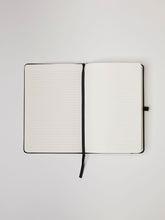 Load image into Gallery viewer, LDNA London black notebook opened up to show the lined paper pages.